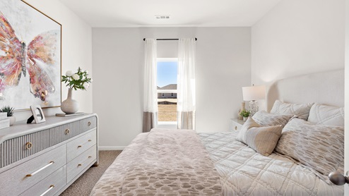 Secondary bedroom with carpet and window