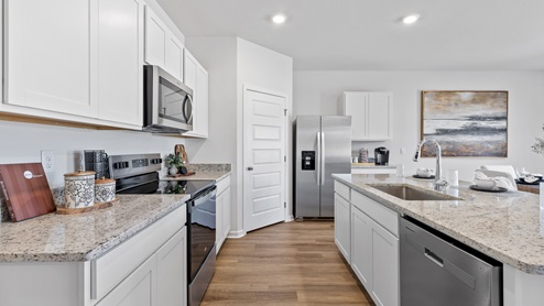 Kitchen island with painted cabinets and stainless steel appliances