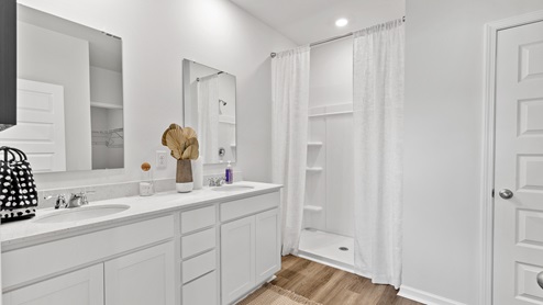 Primary bath with painted cabinets and quartz countertops