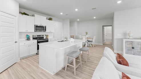 Open kitchen with white quartz countertops and a large pantry.