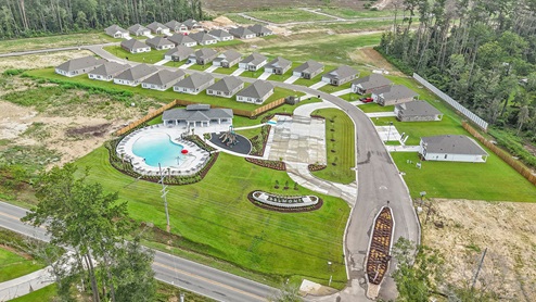 drone image of belmont's community featuring the amenity center with pool and playground