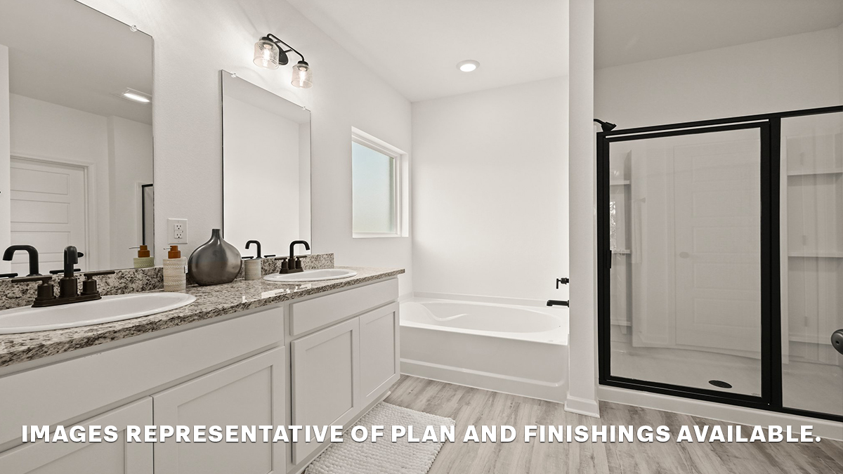 primary bathroom with dual vanities, mirror and separate shower and tub combo