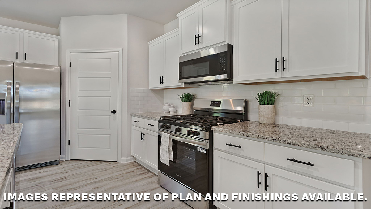 White kitchen island with stainless steel appliances and pantry access