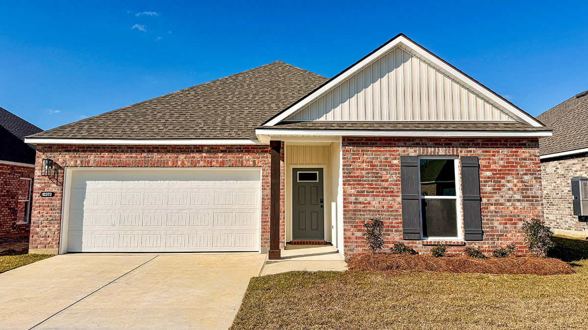 single-story home with red brick and tan vinyl siding with grey front door and shutters with two-car garage