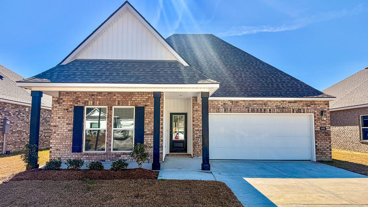 single-story home with ran brick and white vinyl siding along with a large porch with black front door and shutters with two-car garage