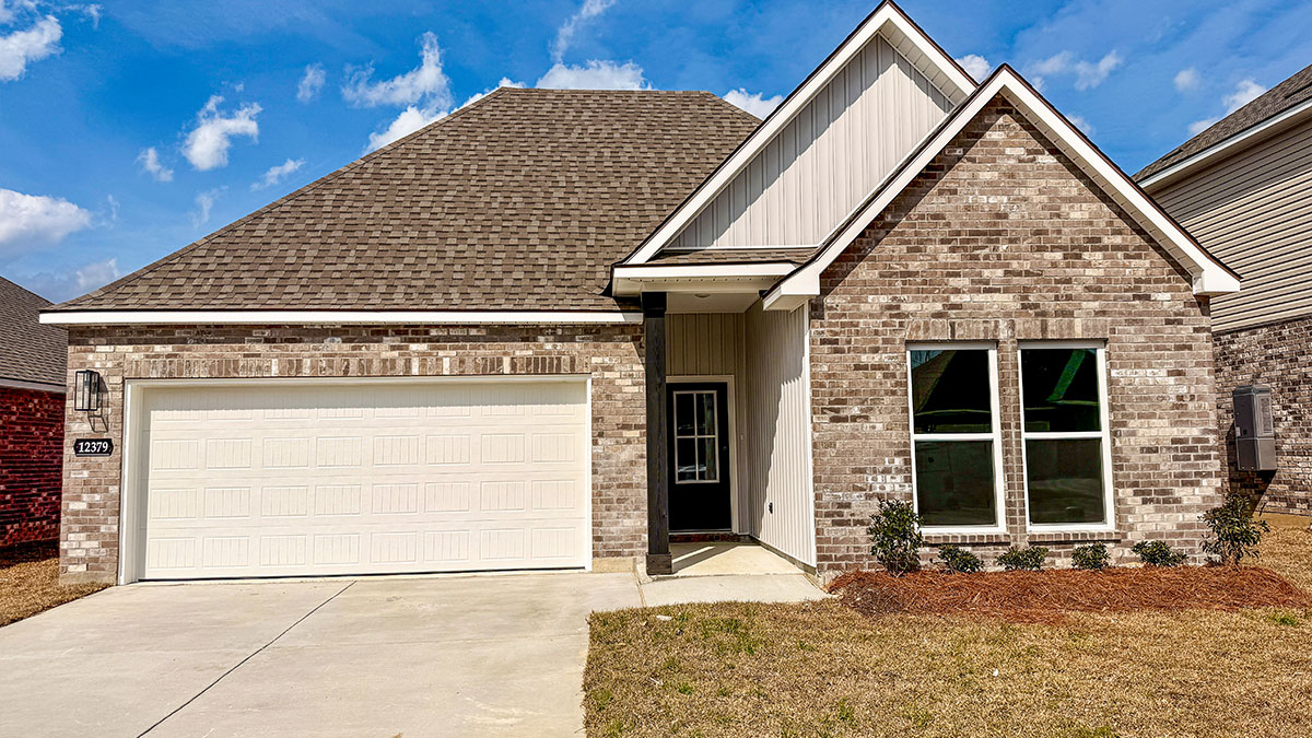 single-story home with grey brick and light gray vinyl siding with grey front door and two-car garage