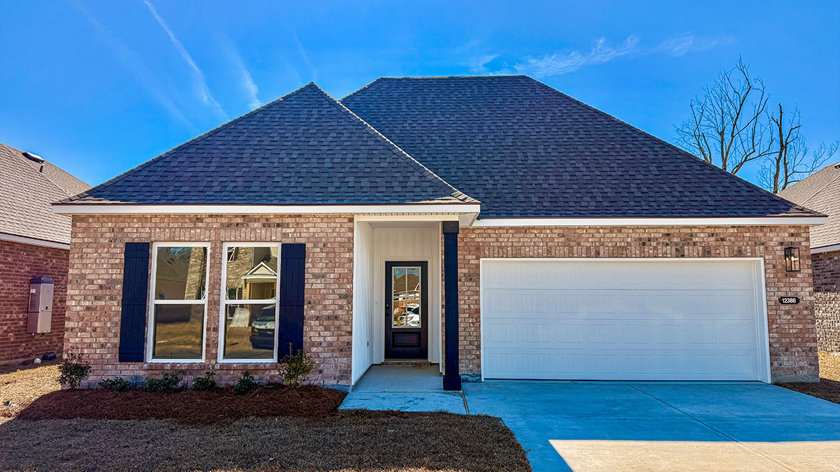single-story home with tan brick and white vinyl siding and black front door and shutters with two-car garage