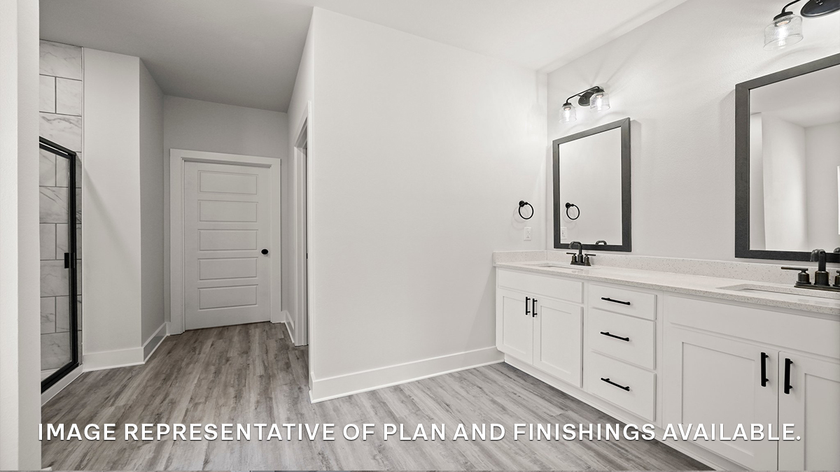 Dual vanities in primary bathroom with separate shower and closet access