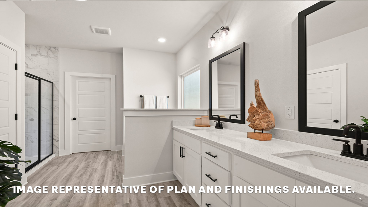 Dual vanities in primary bathroom with separate shower and closet access