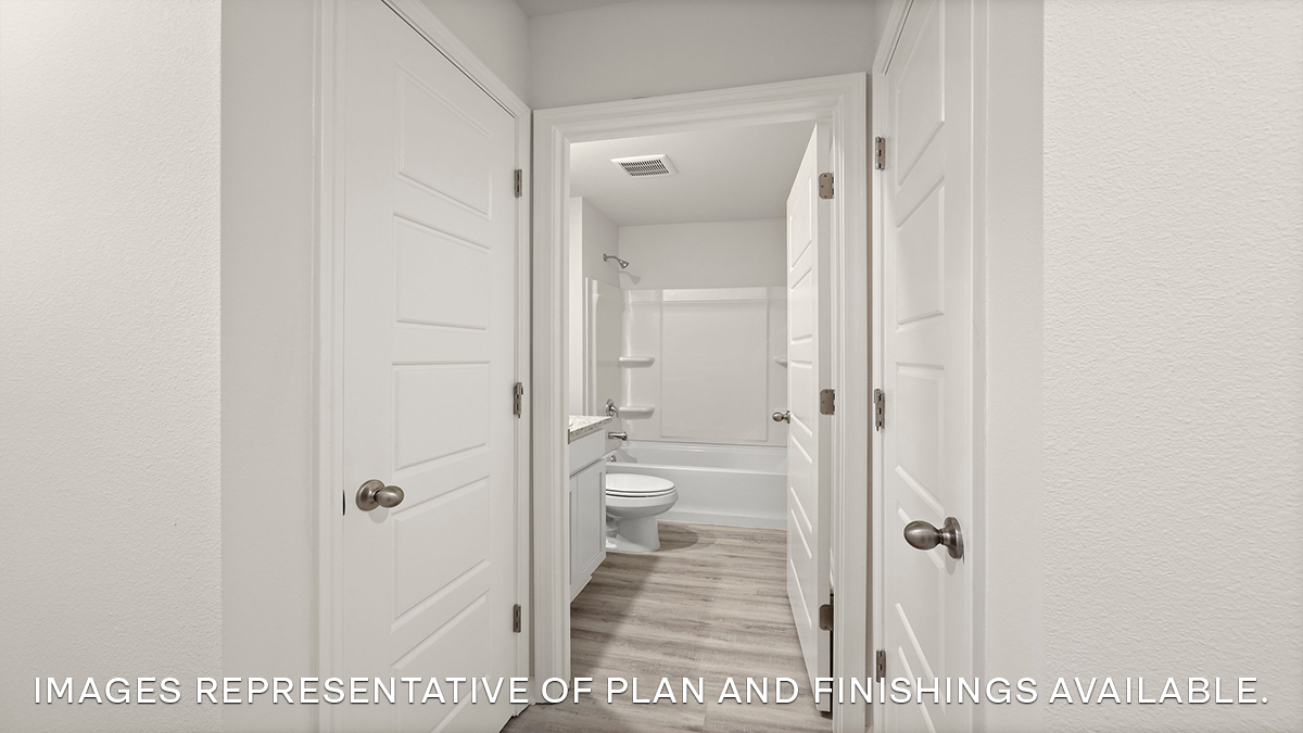 opening foyer with closet and guest bathroom with vanity, toilet and shower tub combo