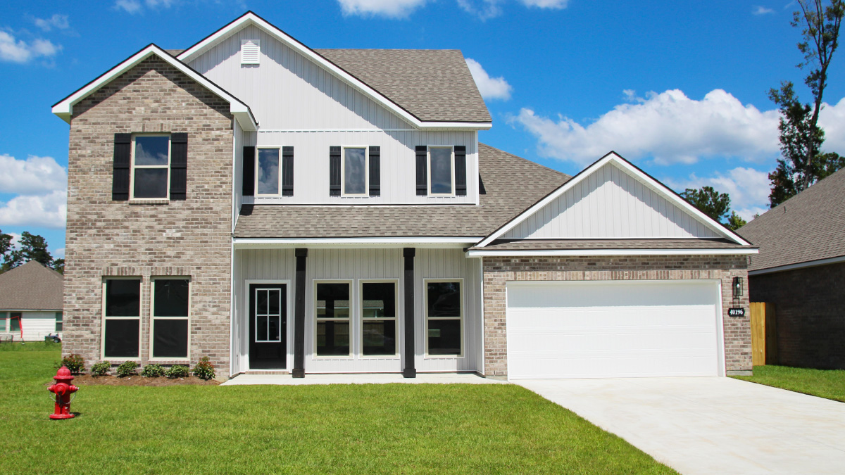 Two-story home with white hardie vinyl and brown brick. Black glass front door with black shutters and white trim.
