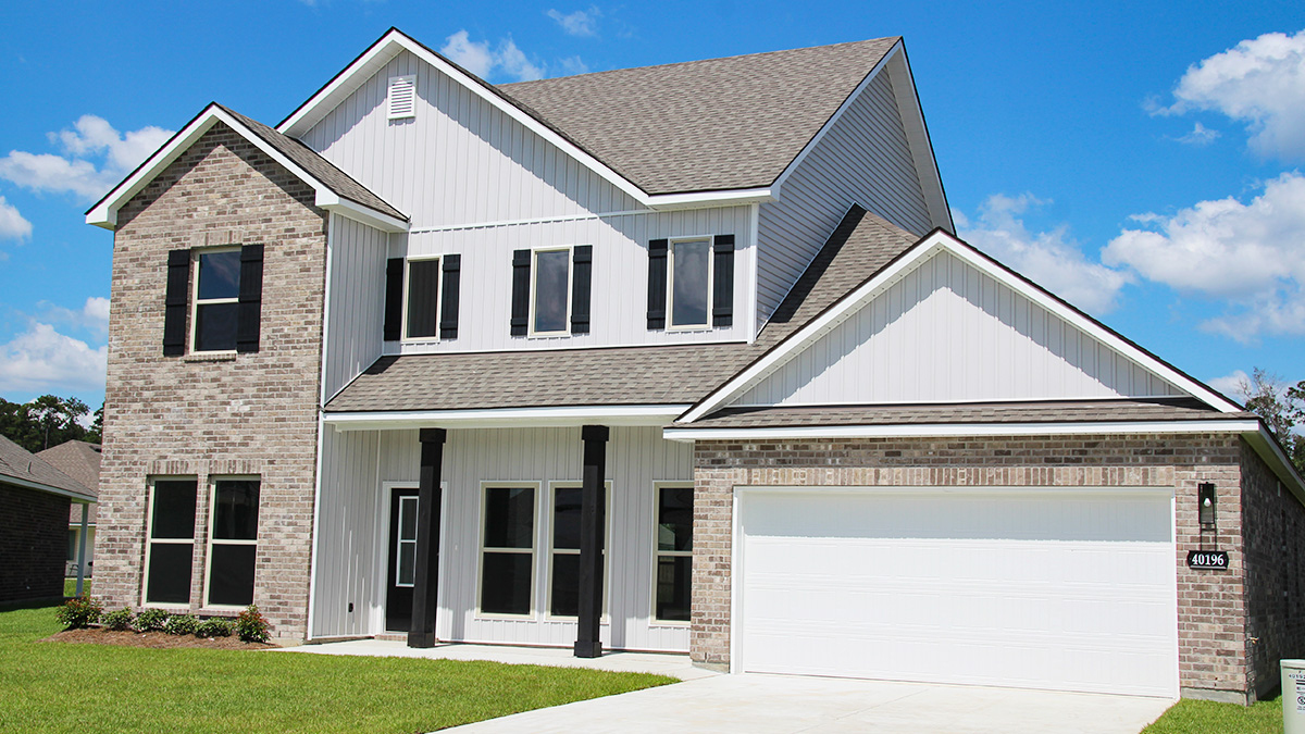 Two-story home with white hardie vinyl and brown brick. Black glass front door with black shutters and white trim.