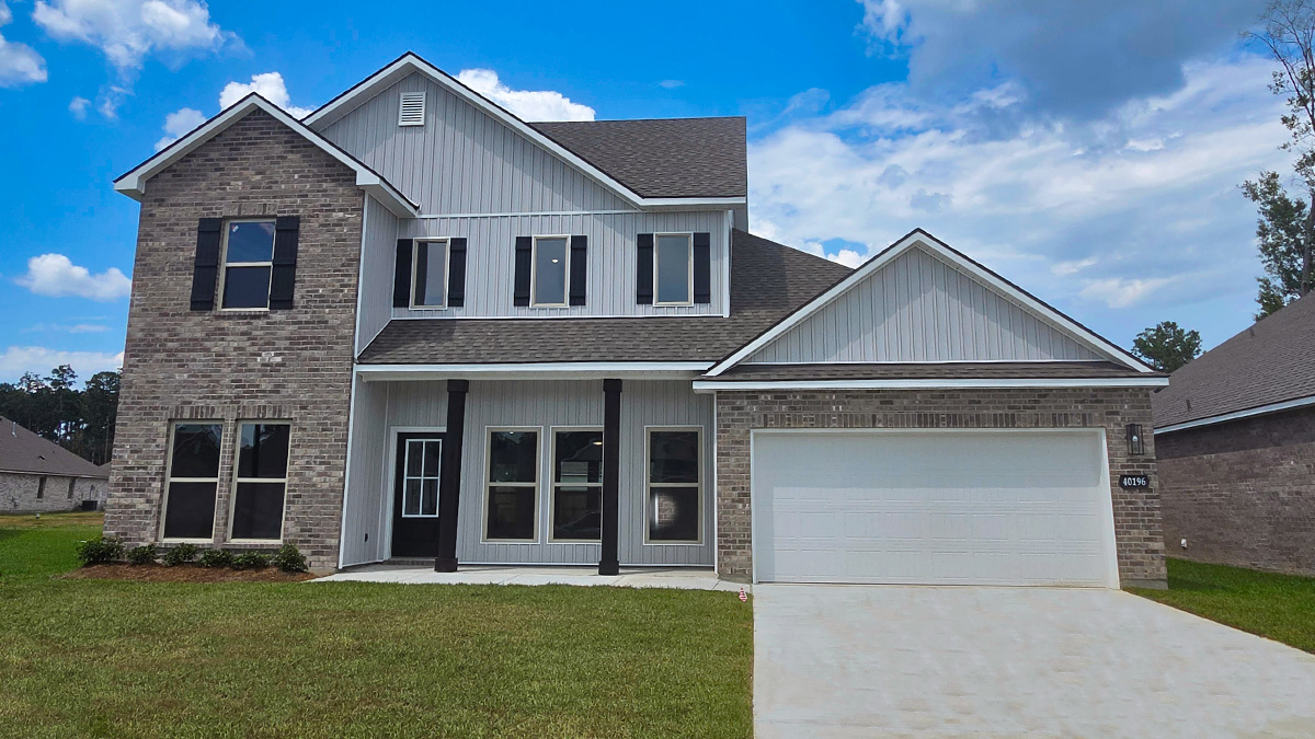 Two-story home with white hardie vinyl and brown brick. Black glass front door with black shutters and white trim.