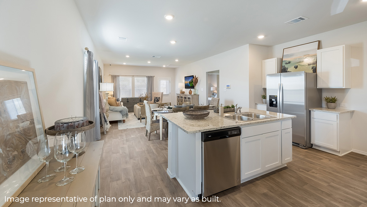 White kitchen island with stainless steel appliances with living room and dining room in the rear