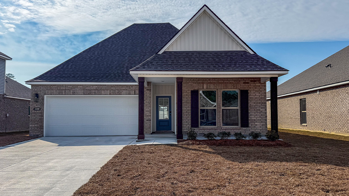 single-story home with red brick and tan vinyl siding, black front door and shutters with porch and two-car garage