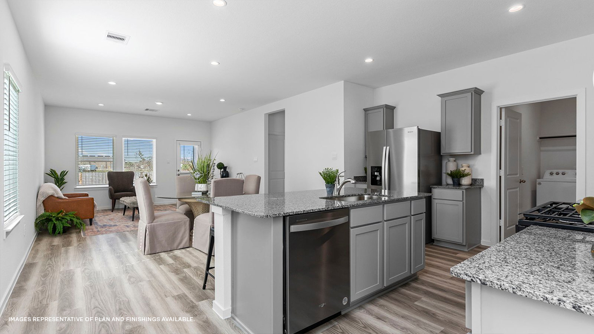 Gray kitchen island with stainless steel appliances and living and dining room in the rear