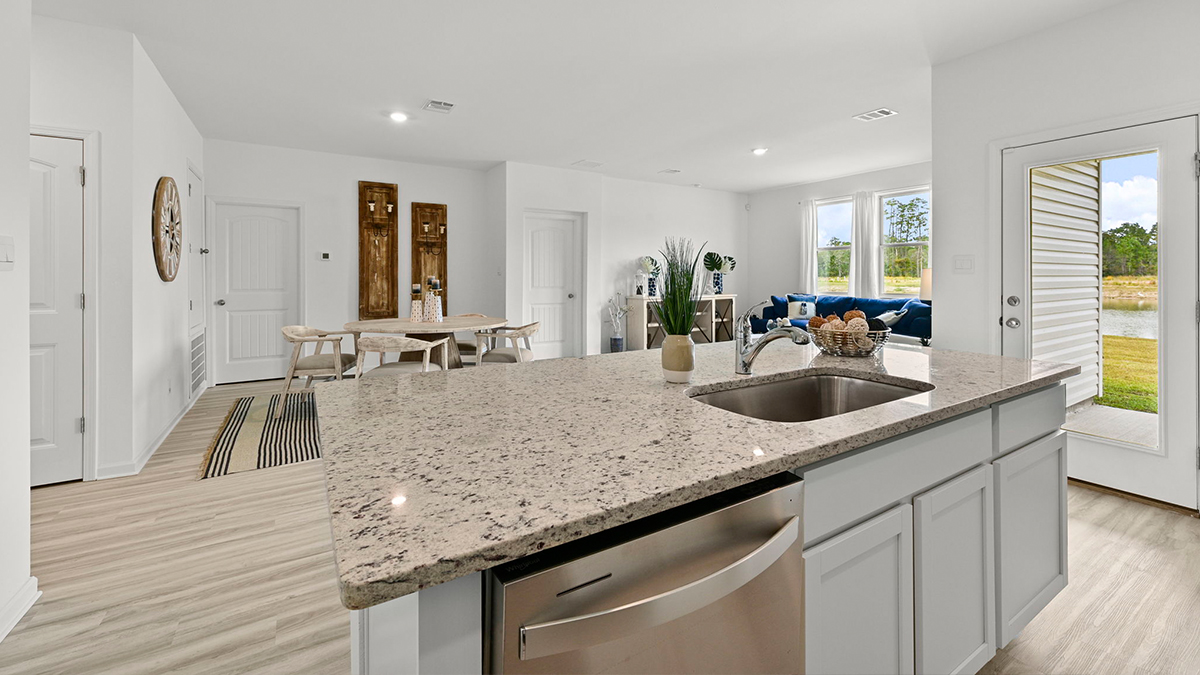 white kitchen island overlooking open-concept dining and living room