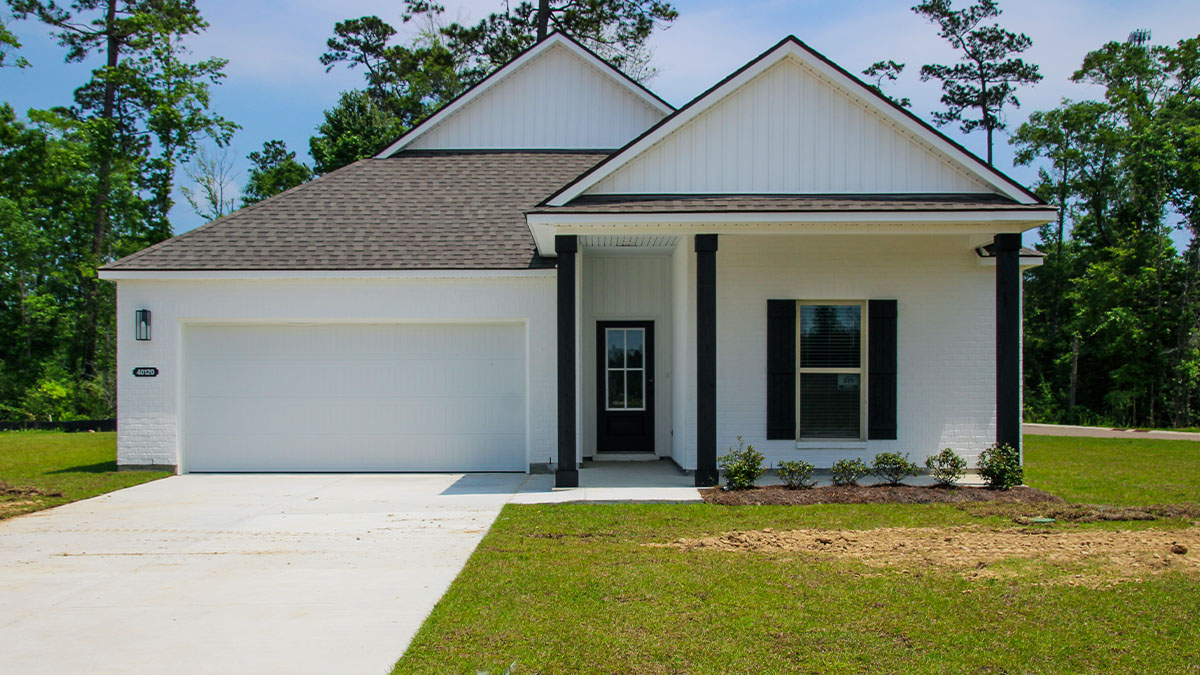 single-story home with white brick and white vinyl siding with black front door and shutters with two-car garage