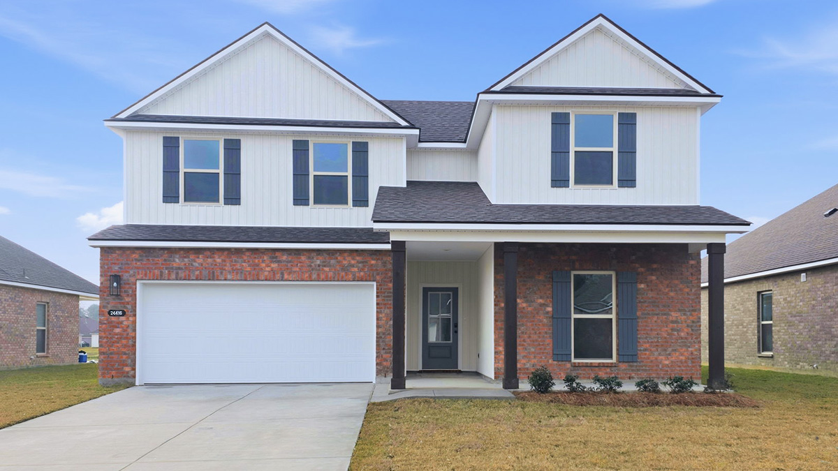 double-story home with red brick and tan vinyl siding with black front door and shutters