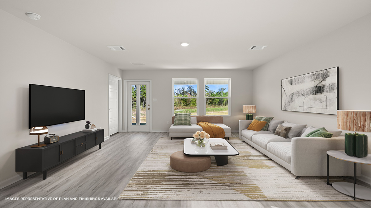 gray kitchen island with living and dining space in the with windows showcasing sun in the space