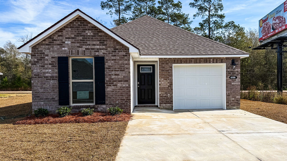 single-story home with grey brick and white vinyl siding and black front door and shutters with one-car garage