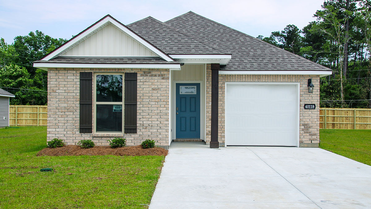 single-story home with tan brick and brown shutters with blue front door and one-car garage