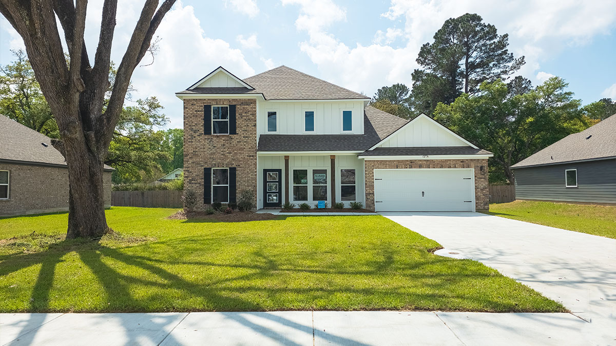 double-story home with tan brick and white vinyl siding with black front door and shutters with porch and two-car garage