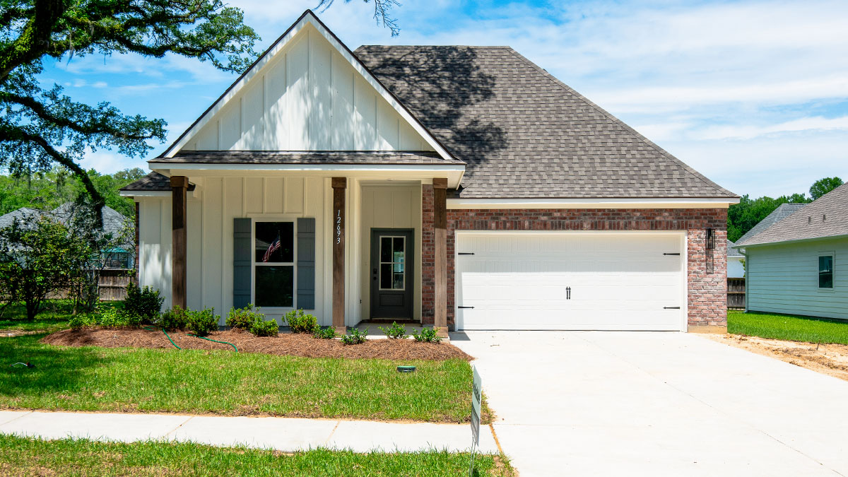 single-story home with tan brick and white hardi siding with two-car garage