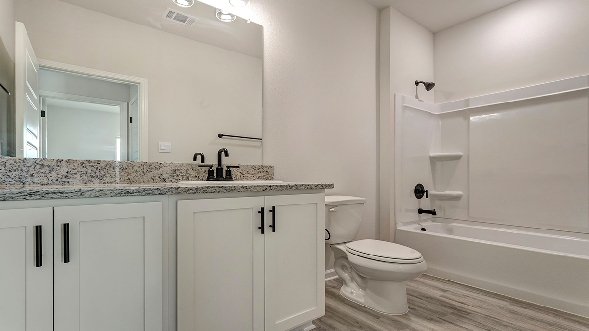 Guest bathroom with single vanity mirror and shower tub combo