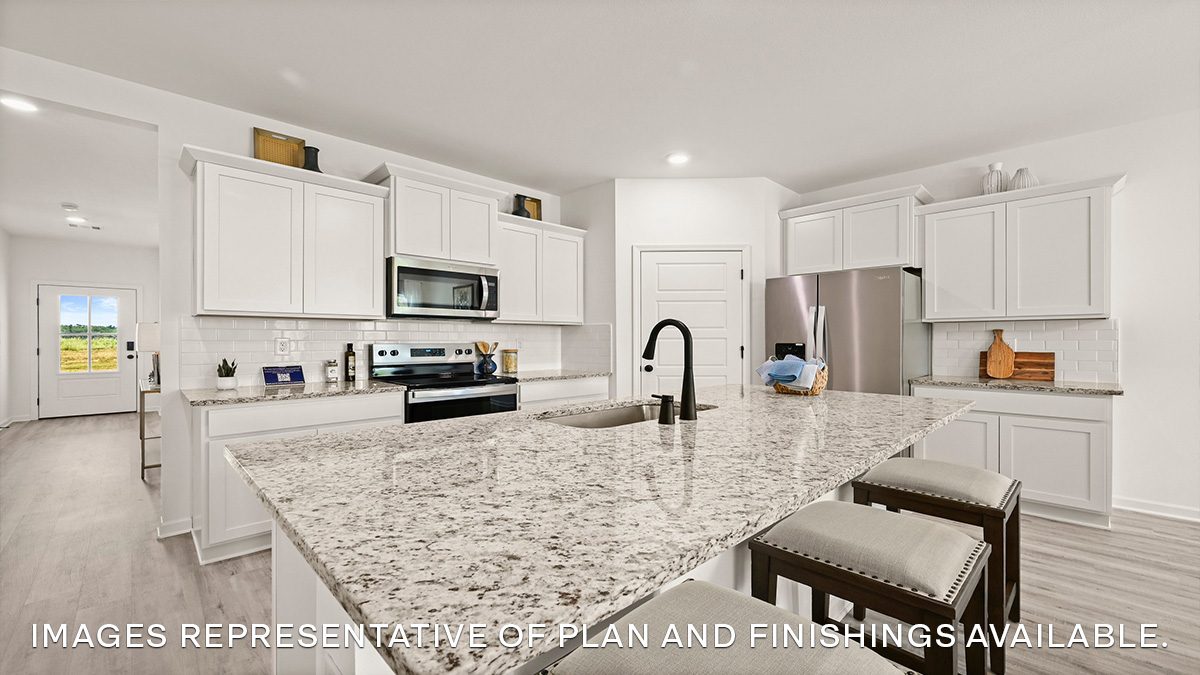 New appliance suite included and central kitchen island with sink and seating, next to dining, great room, and outdoor access