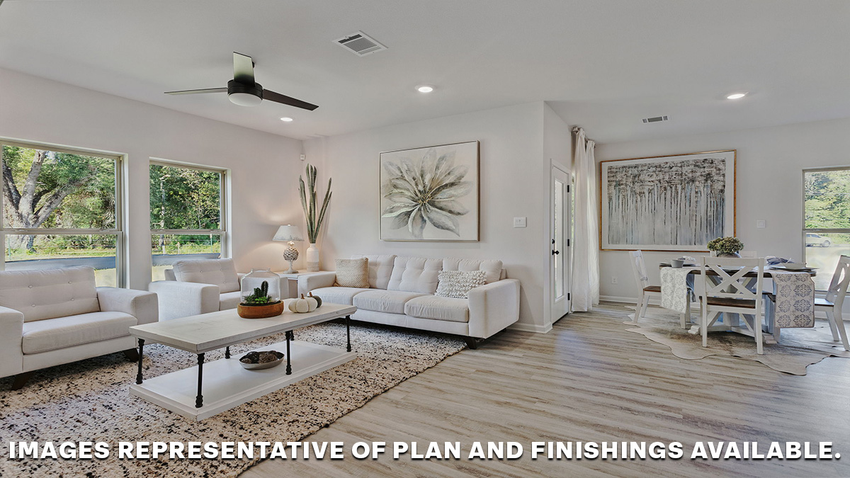 Living room with dual windows overlooking the backyard with the dining space nearby
