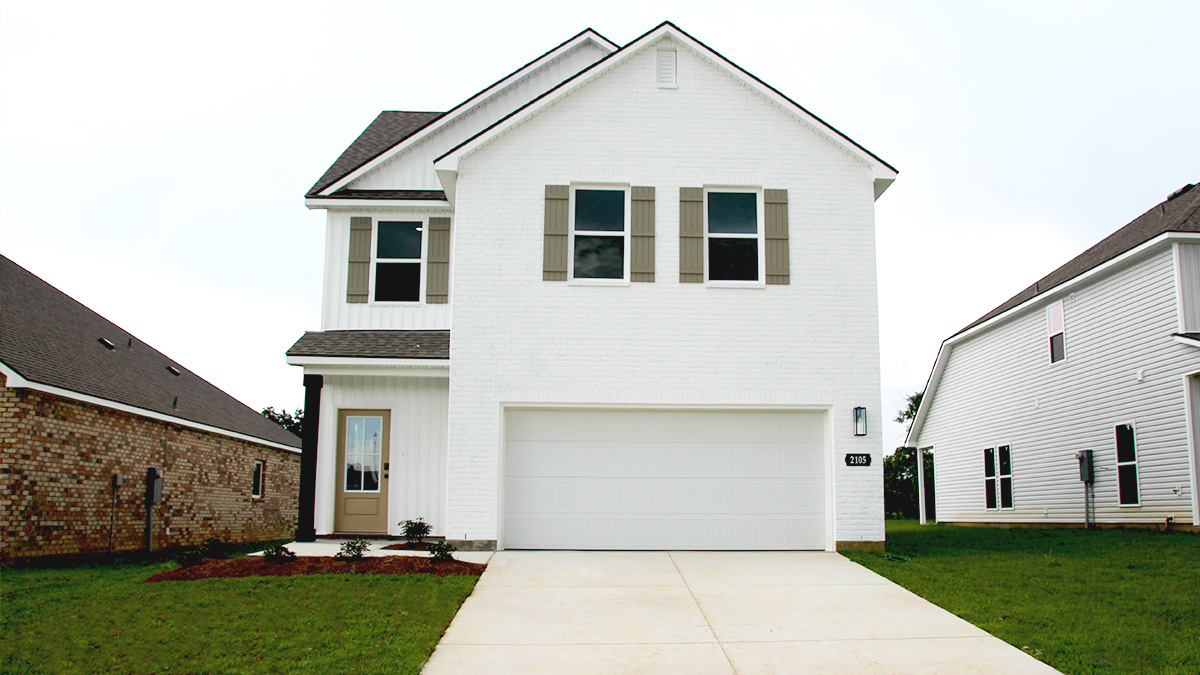 Two-story home with white hardie vinyl and white brick. Tan glass front door with tan shutters and white trim.