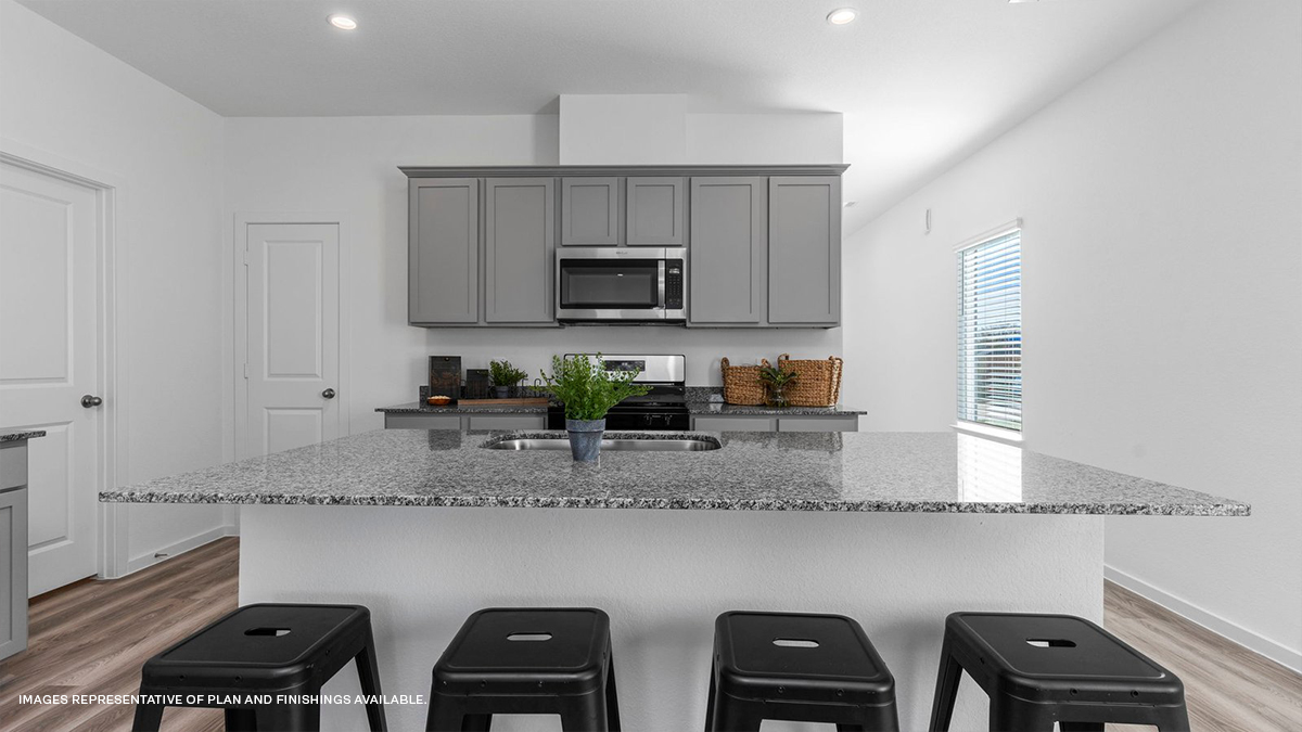 Gray kitchen island with stainless steel appliances and stools