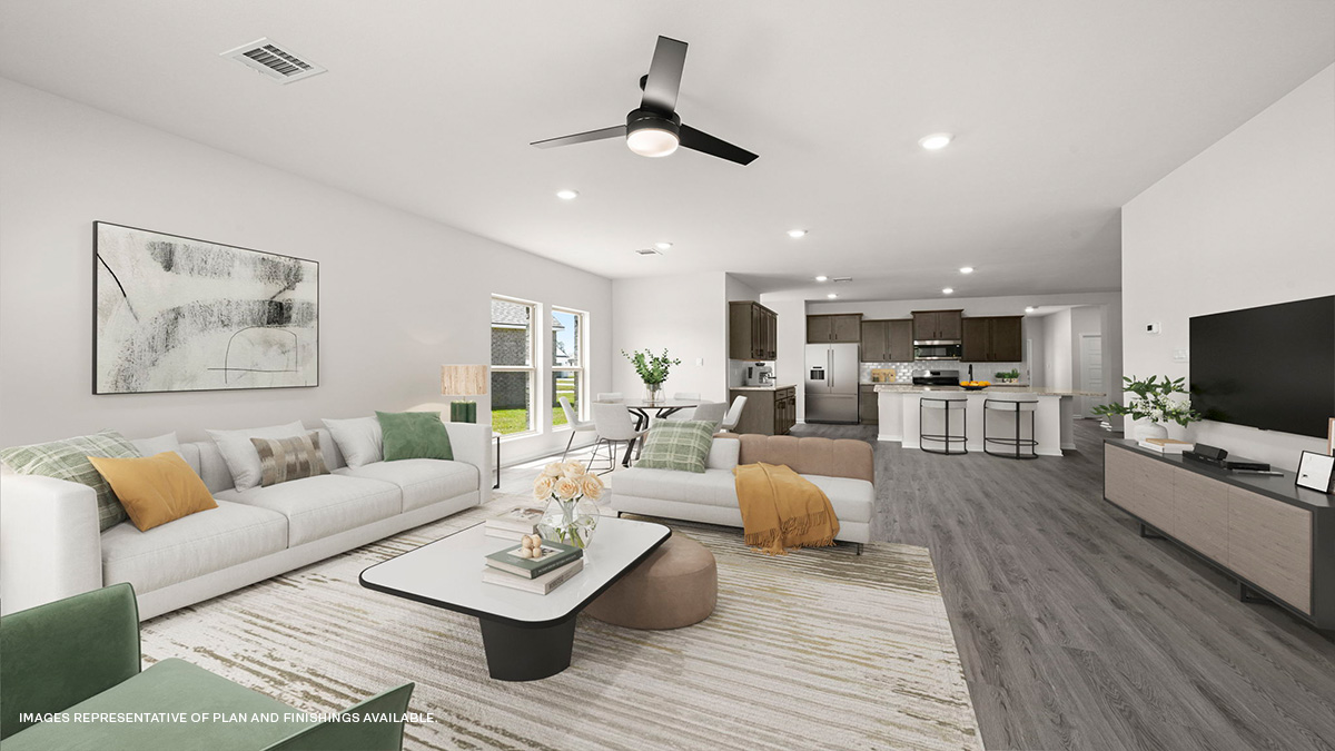 living and dining area with kitchen area in the rear with dark kitchen cabinets and fan