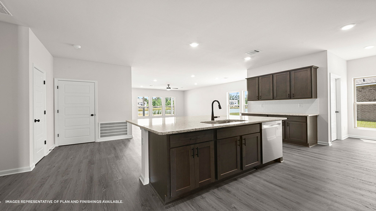 dark kitchen island with stainless steel appliances and open-concept living space in the rear