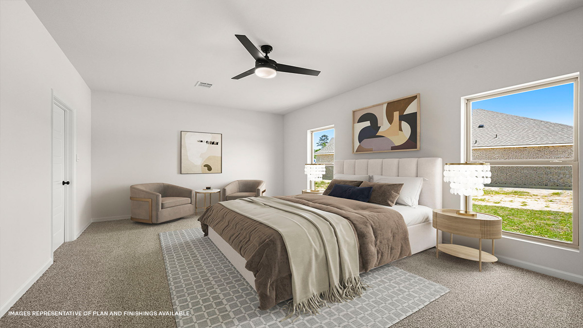 primary bedroom with fan and dual windows with access to bath