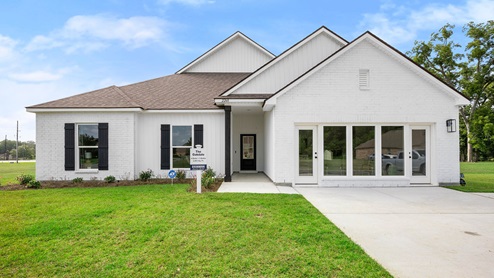 white single-story home with white brick and black front door and shutters
