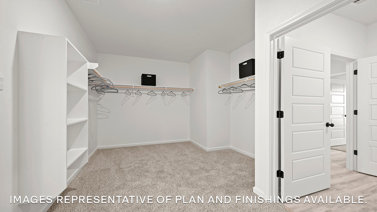 spacious walk in closet with dual shelving and racks with room for a shoe shelf