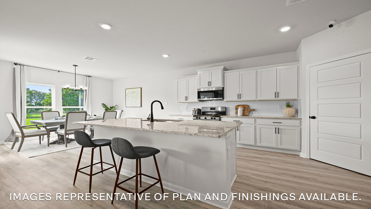 white kitchen island with white cabinets and stainless steel appliances with dining room to the left