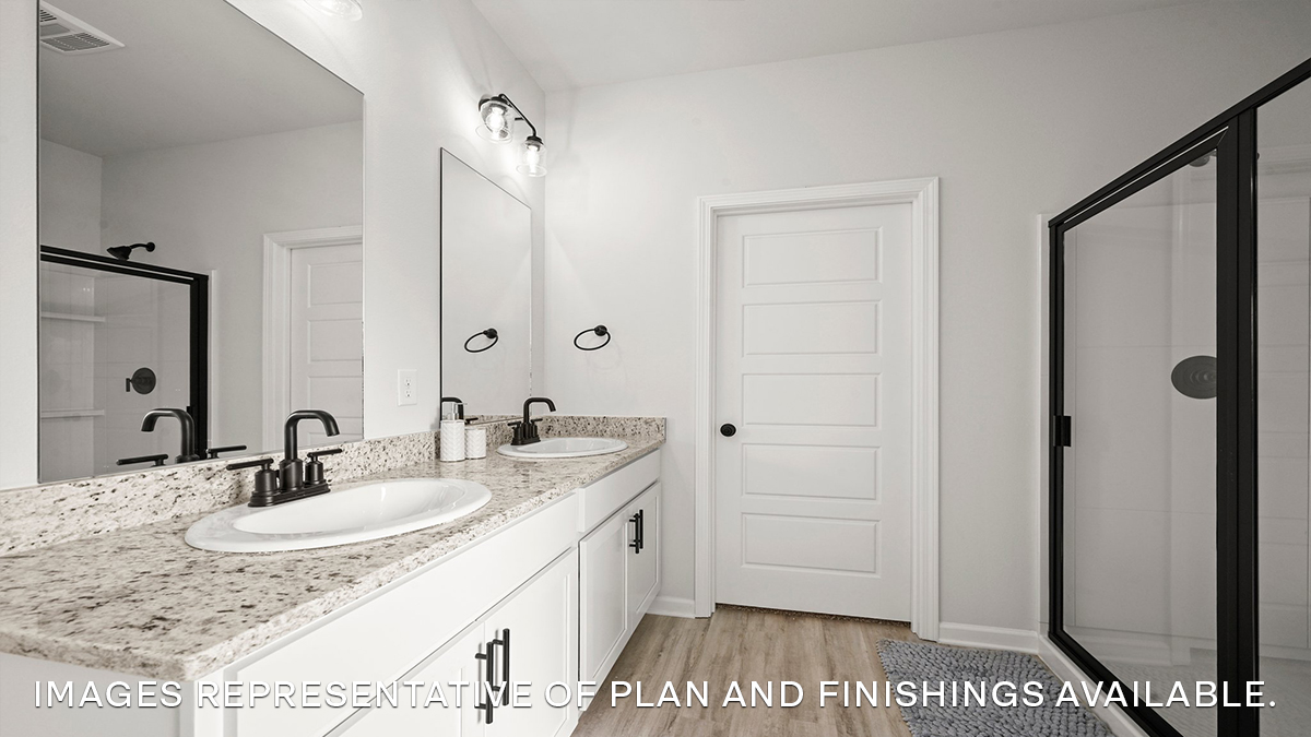 primary bathroom with dual vanity and separate tub and shower