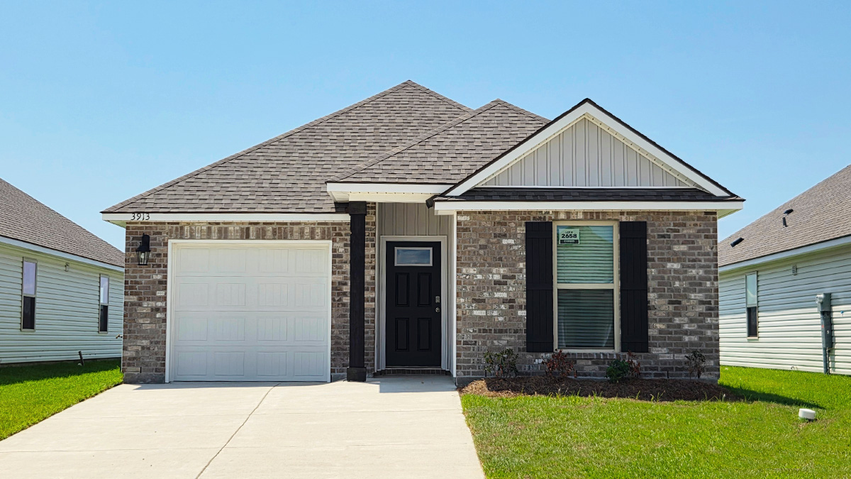 Single-story home with brown brick. Black glass front door with black shutters and white trim.