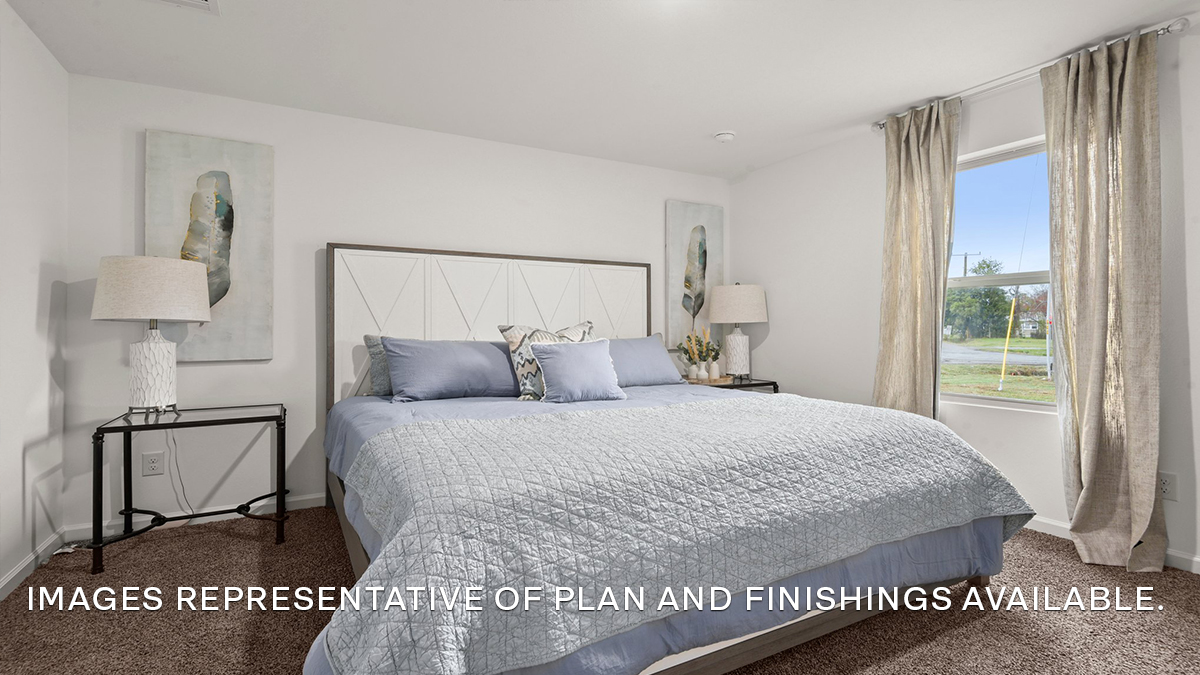 Large primary bedroom with dual windows overlooking the backyard