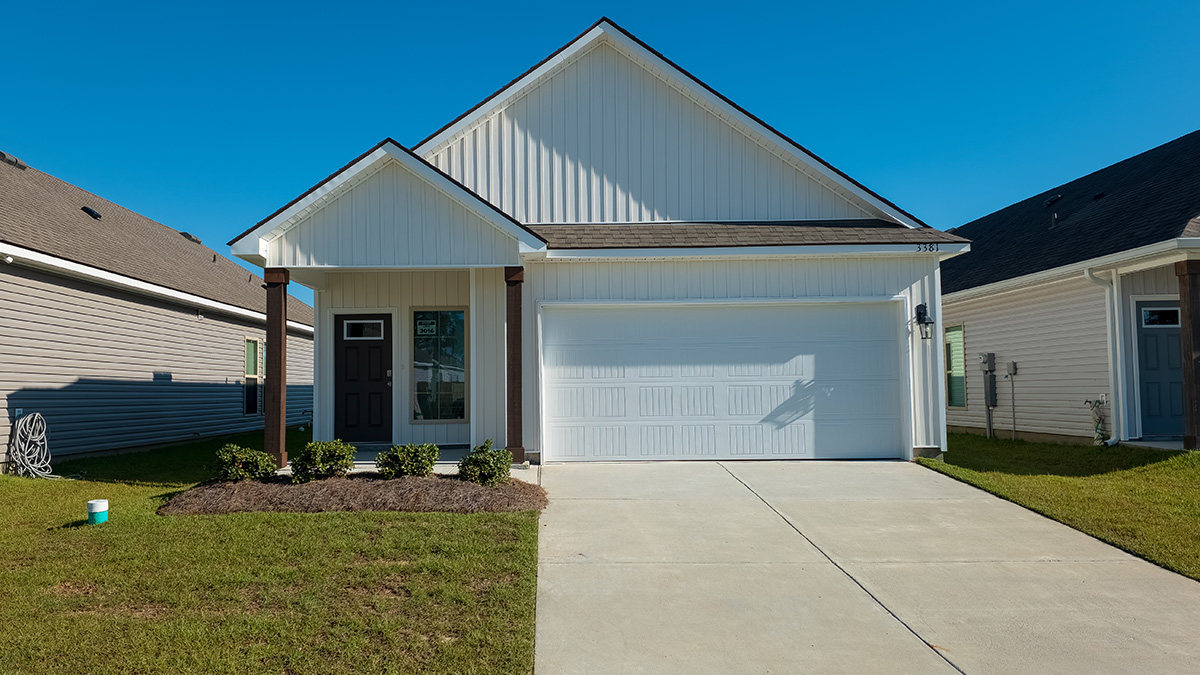 single-story home with tan vinyl siding with black door with two-car garage and porch
