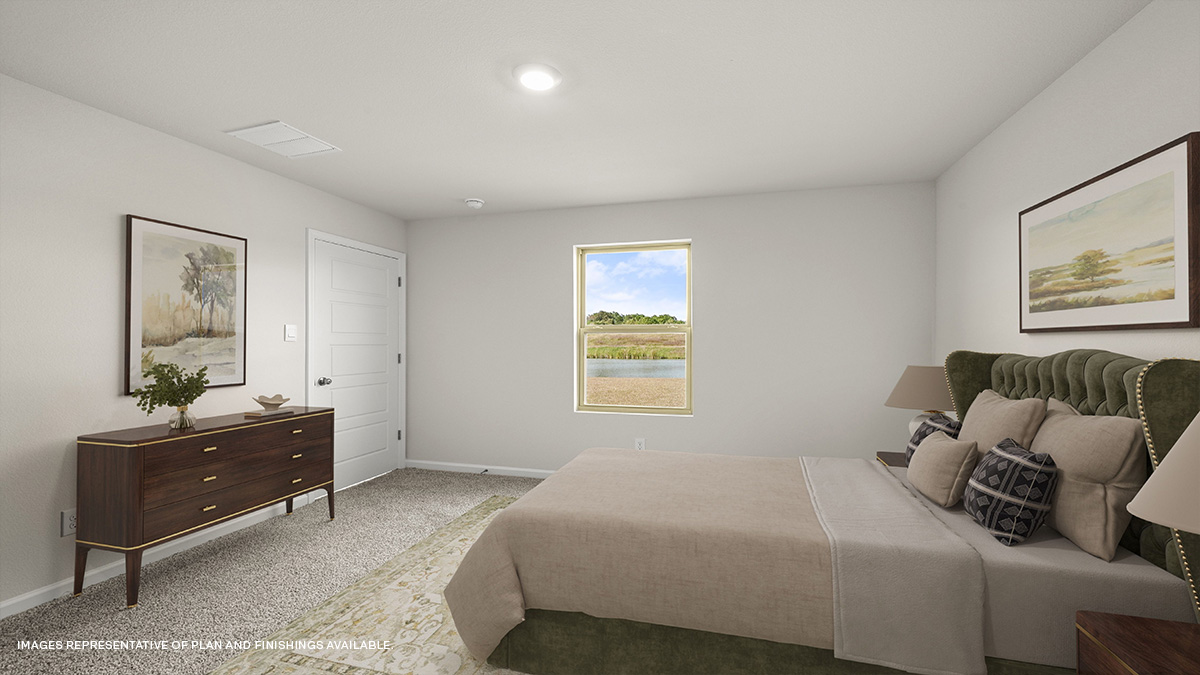 Large primary bedroom with dual windows overlooking the backyard
