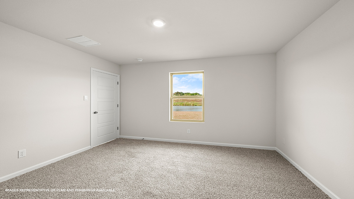 Large primary bedroom with dual windows overlooking the backyard
