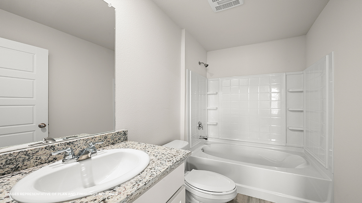 White dual vanities with shower and tub combo and toilet