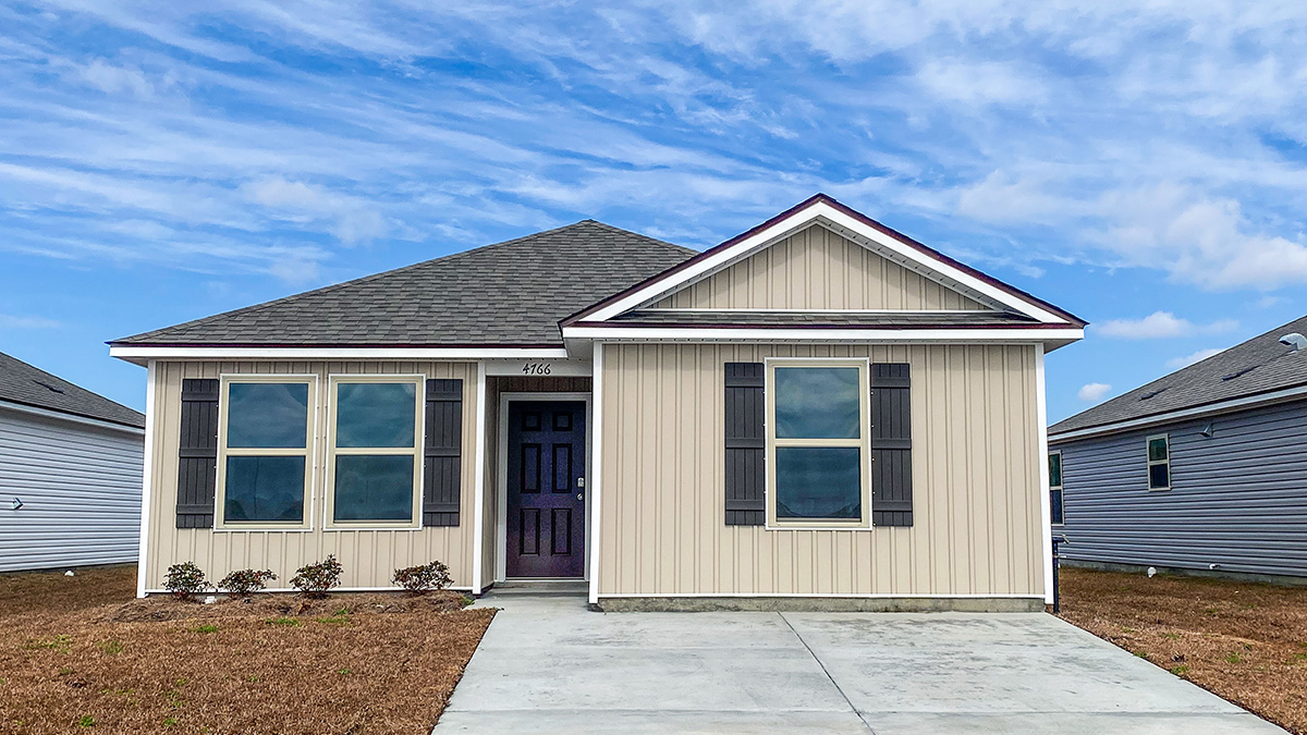 single-story home with beige vinyl siding with black front door and shutters
