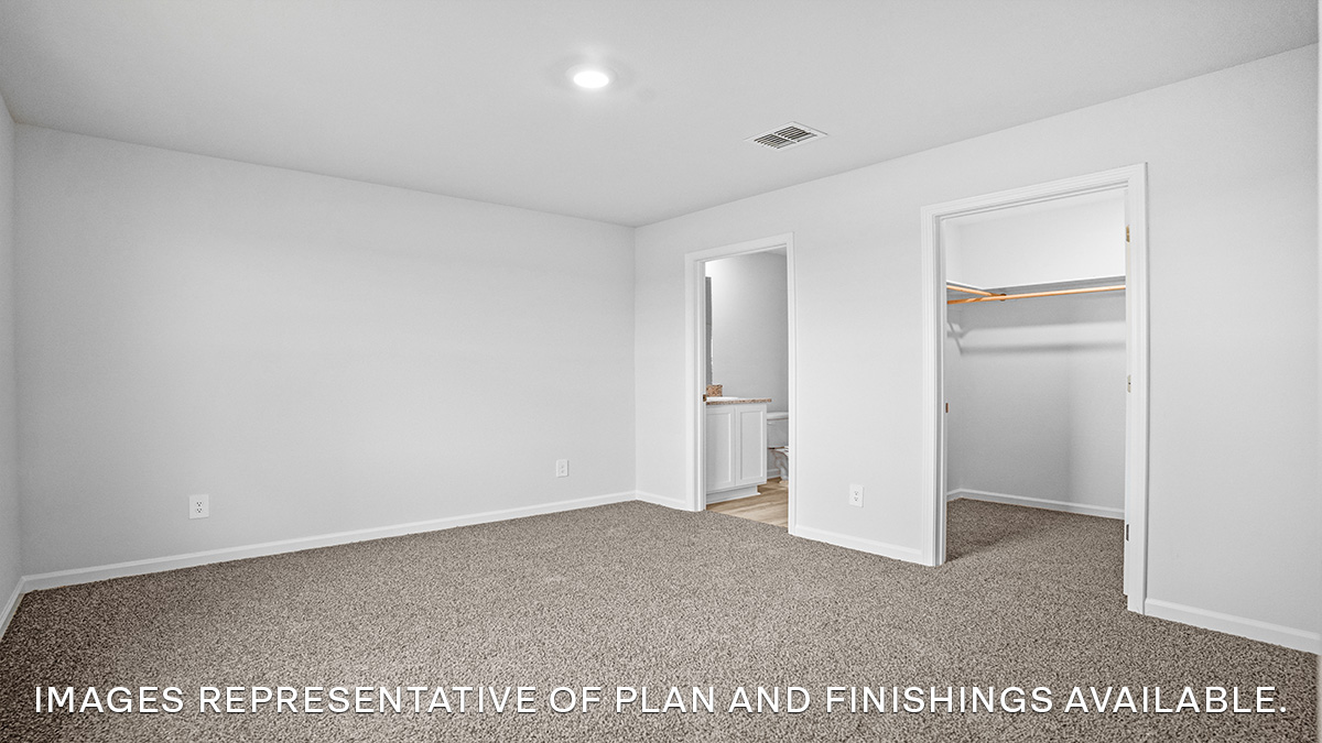 Large primary bedroom with dual windows overlooking the backyard