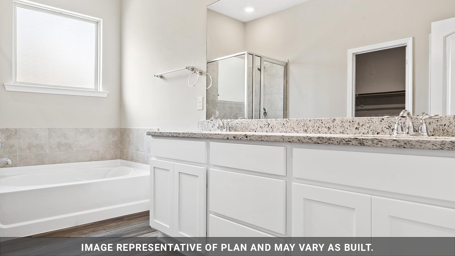 primary bath with dual vanities and garden tub