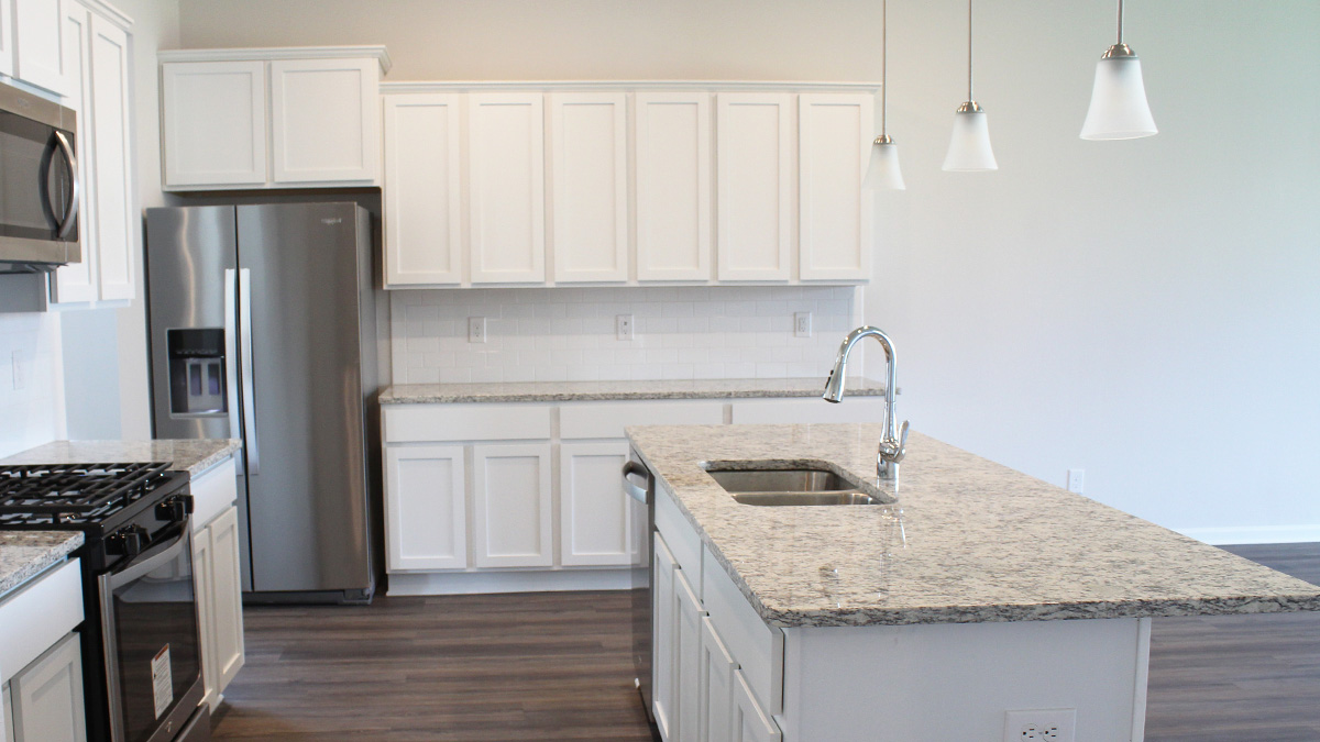 Kitchen with white soft closed cabinets and stainless steel appliances and large island